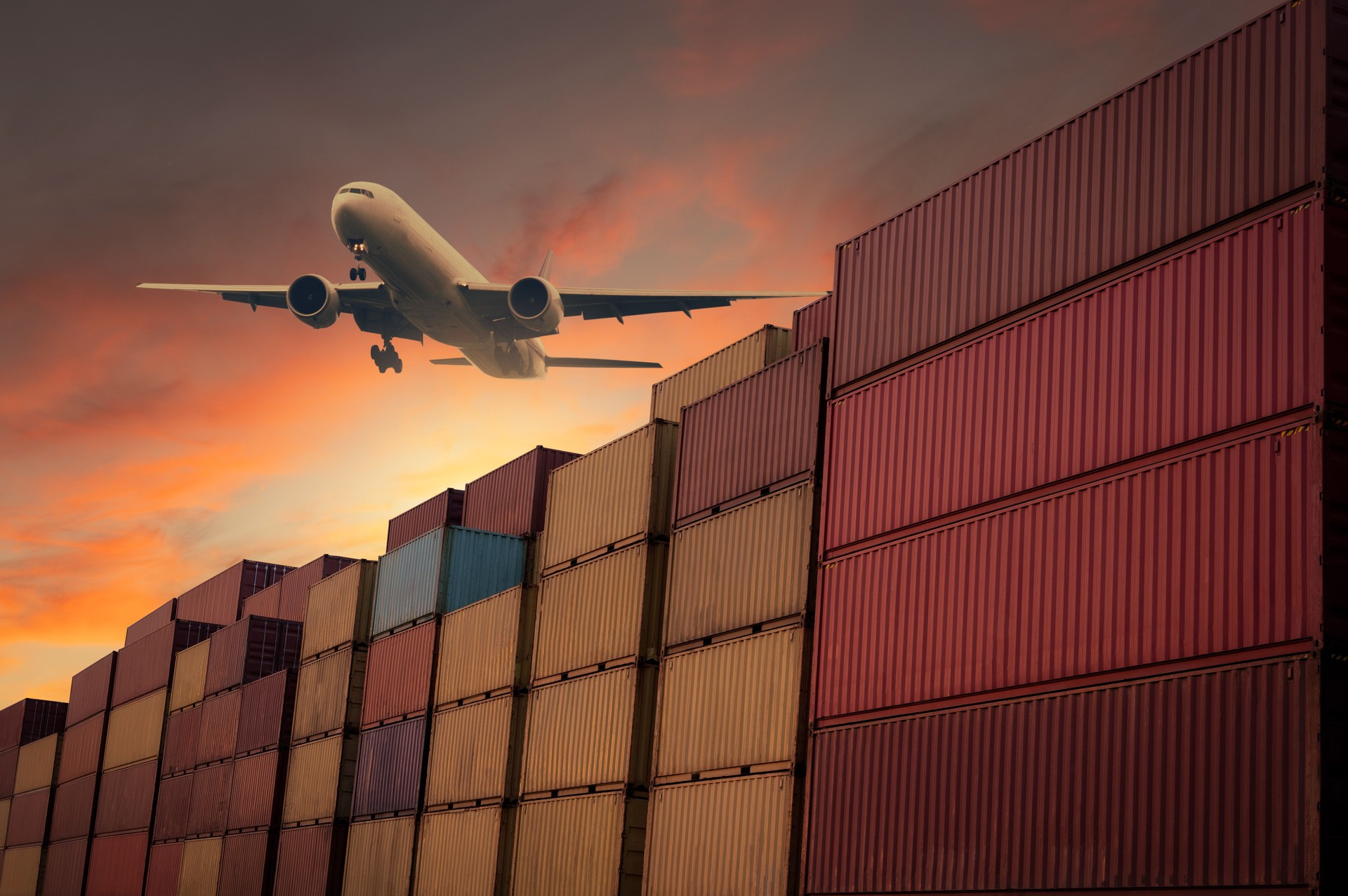 A cargo plane for logistics and transportation business theme sits above a container warehouse.